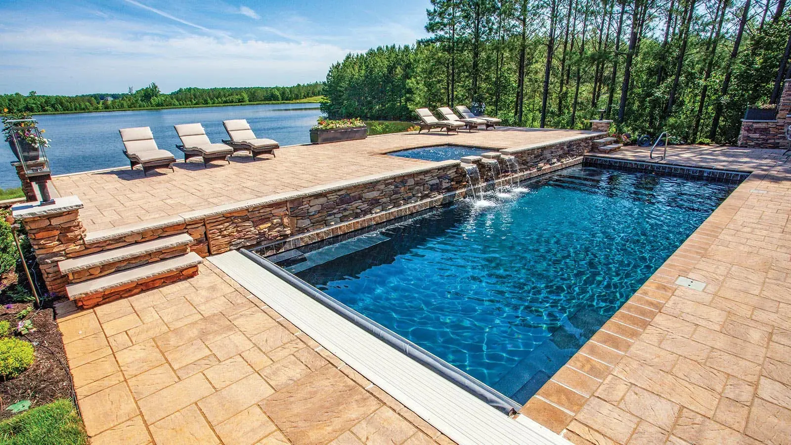 Poolside view with loungers and lake background.