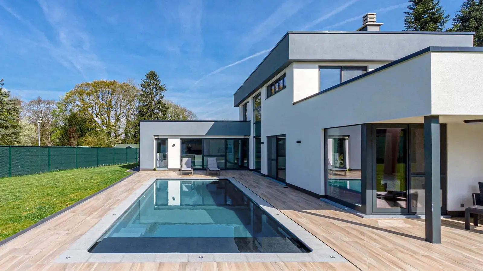 Modern house with pool and wooden deck.